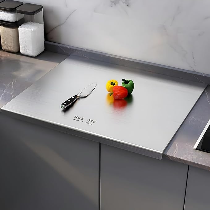 Woman chopping vegetables on stainless steel cutting board in a kitchen in Lahore.